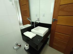 a bathroom with a sink and a mirror at Capitólio Home Suítes in Capitólio +56 photos