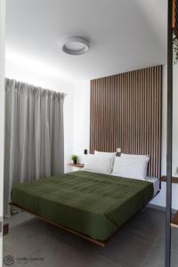 una camera da letto con un letto grande con una coperta verde di Corfu Garden Villas a Città di Corfù Altre 59 foto