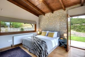 a bedroom with a bed and a stone wall at Amfikleia Chalet in Amfiklia