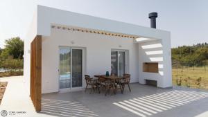 una casa bianca con tavolo e sedie di Corfu Garden Villas a Città di Corfù