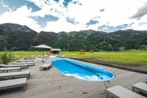 a pool on a deck with chairs and a mountain at Rancho Texas in Kurort Chemal