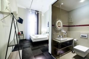 een badkamer met een bed, een wastafel en een spiegel bij Home Aparthotel in Krakau