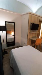 1 dormitorio con cama, escritorio y espejo en Hotel Balneario El Raposo en Puebla de Sancho Pérez