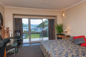 una camera d'albergo con un letto e una grande finestra di Beachcomber Inn Picton a Picton