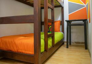 a bedroom with two bunk beds with an orange bed at Onde Pepe Hostel in Bogotá