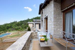 a stone house with a balcony with a pool at Amfikleia Chalet in Amfiklia