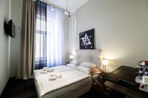 een slaapkamer met een bed met een bureau en een bed sidx sidx sidx bij Home Aparthotel in Krakau