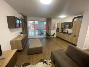 a living room with a couch and a kitchen at Rekord Park Apartments in Cluj-Napoca