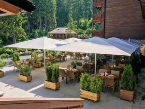 a restaurant with tables and umbrellas on a patio at Teleferic Grand Hotel in Poiana Brasov