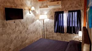 - une chambre avec un lit et une télévision à écran plat dans l'établissement Trinacria, à Catane