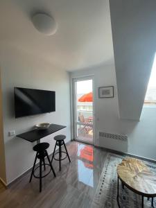a living room with a table and two stools at Hello 3B Apartman in Keszthely