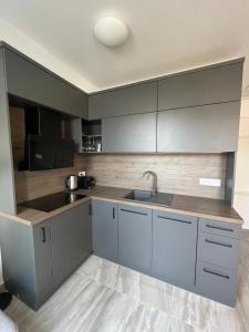 una cocina con armarios grises y fregadero en Hello 3B Apartman en Keszthely