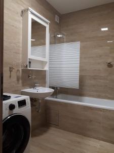 La salle de bains est pourvue d'un lavabo, d'une baignoire et d'un lave-linge. dans l'établissement Kosice-centrum apartment, à Košice