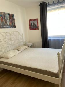 - un lit blanc dans une chambre avec fenêtre dans l'établissement Kosice-centrum apartment, à Košice