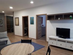 Una sala de estar con una mesa y un televisor. en Kosice-centrum apartment, en Košice