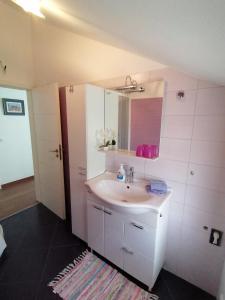 a bathroom with a white sink and a mirror at Lily Apartments Punta Skala in Petrcane