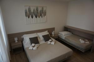 twee bedden in een hotelkamer met handdoeken erop bij Azzìsa Holidays Suite in Palermo