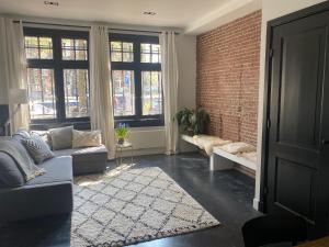 a living room with a couch and a brick wall at Amstel Boutique Studio in Amsterdam