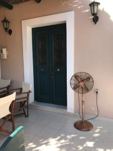a door with a fan in front of a house at Villa Theoni in Halki