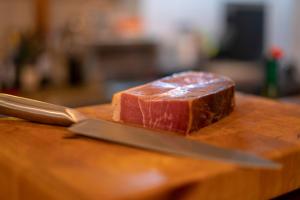 un pezzo di carne su un tavolo di legno con un coltello di Casa do Palheiro a Campo do Gerês Altre 5 foto