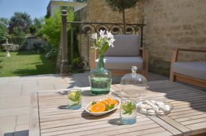 une table avec un vase de fleurs et un bol d'oranges dans l'établissement Chambres d'hôtes - La Maison 19, à Niort