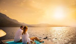 a man and a woman sitting on a boat in the water at Aminess Younique Korcula Heritage Hotel in Korčula