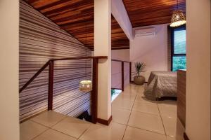 een kamer met een trap in een huis met een bed bij APARTAMENTO 2 QUARTOS EQUIPADO NO BOSQUE DA PRAIA FLATS - PIPA NATUREZA in Pipa