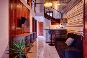 a living room with a couch and a staircase at APARTAMENTO 2 QUARTOS EQUIPADO NO BOSQUE DA PRAIA FLATS - PIPA NATUREZA in Pipa