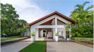 een huis met een binnenplaats met gras en bomen bij Lux Villa Casa de Campo in La Romana