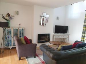 a living room with two couches and a fireplace at Golden Plover at Plover Cottage Lindley in Huddersfield