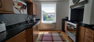 a kitchen with black counter tops and a window at Golden Plover at Plover Cottage Lindley in Huddersfield