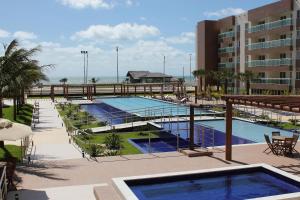 Una vista de un complejo con dos piscinas y un edificio. en AllMar Flats - Vg Fun - Frente mar, en Fortaleza