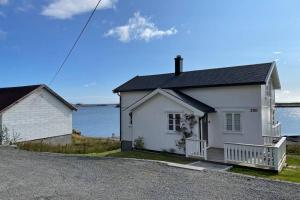 Nordlandshus ved havet på Reine, Lofoten في راين: بيت ابيض بجانب تجمع المياه