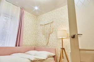 sypialnia z różową kanapą i oknem w obiekcie Тихое место на набережной Лазури w mieście Twer