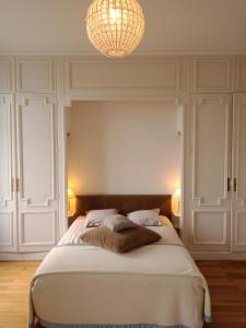 una camera da letto con un letto grande con un lampadario di Chateau du Breuil a Beaulieu-sur-Layon
