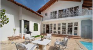 a house with a patio with chairs and a table at Lux Villa Casa de Campo in La Romana