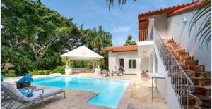a swimming pool in front of a house at Lux Villa Casa de Campo in La Romana