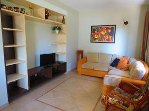 a living room with a couch and a tv at 411- Casa para 8 pessoas 20 metros da Praia Central em Bombinhas in Bombinhas