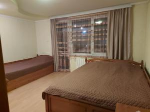 a bedroom with two beds and a window at Къща за гости МЕЛИСА in Borino
