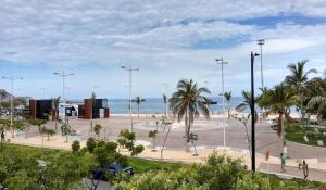 a park with palm trees and the ocean in the background at Hotel Bahia Blanca in Santa Marta