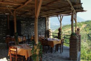 um restaurante com mesas e cadeiras sob um telhado em S.Maria degli Angeli C. Ospitalità em Alvignanello