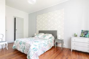 a white bedroom with a bed and a dresser at Ombrelle in Le Pian-sur-Garonne