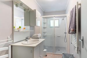Un baño blanco con lavabo y ducha. en Ombrelle, en Le Pian-sur-Garonne 4 fotos más