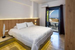 a bedroom with a large white bed and a balcony at Christianna & George Luxury Hot Tub Apartment in Fira