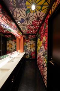 a colorful bathroom with two sinks and a mosaic ceiling at esports hotel e-ZONe 電脳空間 in Osaka