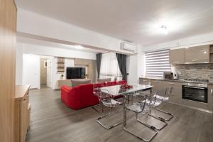 een woonkamer met een rode bank en een tafel bij Luxury Ultracentral in Piteşti