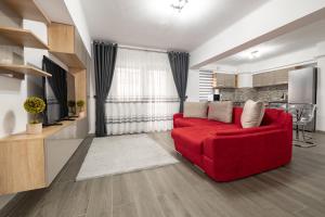 a living room with a red couch and a kitchen at Luxury Ultracentral in Piteşti