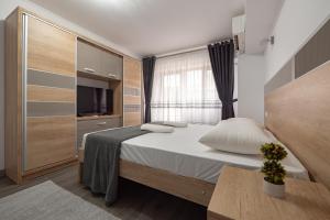 a small bedroom with a bed and a television at Luxury Ultracentral in Piteşti