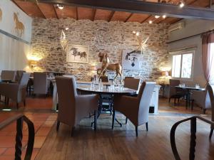 a dining room with a table with a horse statue on it at Restaurant et Chambres d'Hôtes La Ferme de Cornadel in Anduze