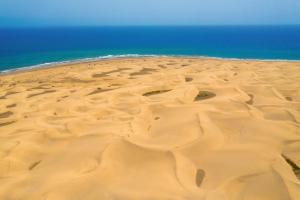 an aerial view of a sandy beach with the ocean at Hotel Riu Palace Maspalomas - Adults Only in Maspalomas
